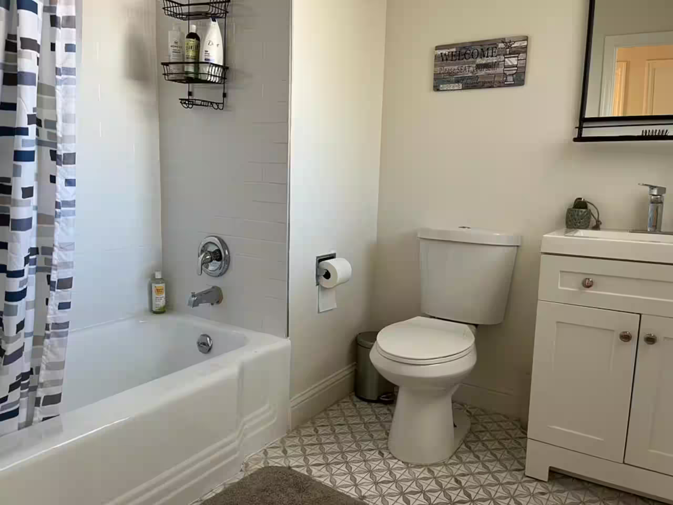 Full bathroom with a shower/tub combo, toilet, and vanity