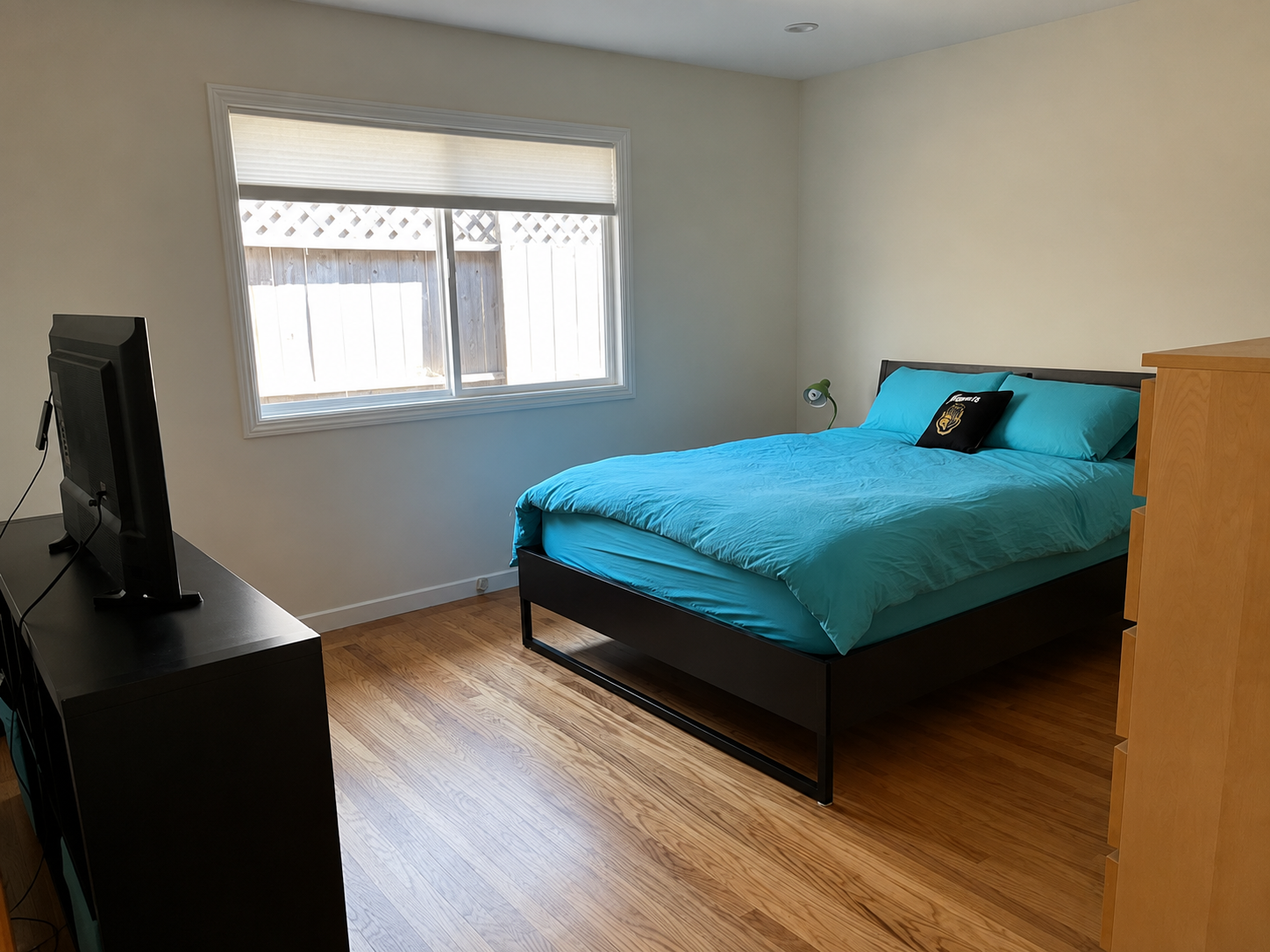 Third bedroom with a queen bed, dresser, and TV